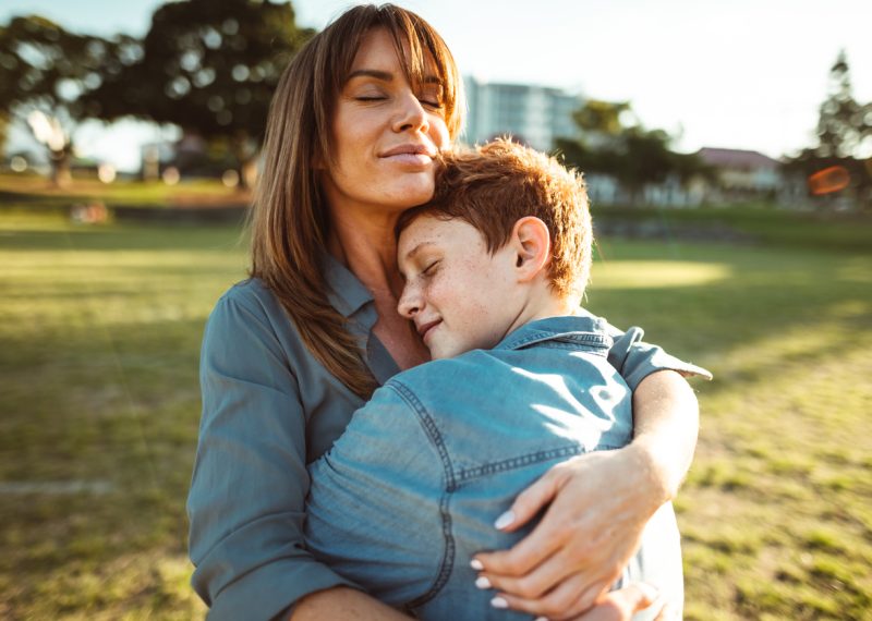 teenager embraced with mom consoling her son