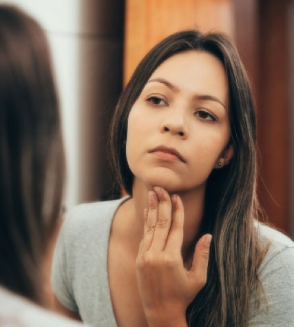 A woman performing a thyroid self-check exam
